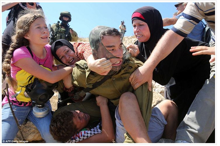 Women and children of Nabi Saleh ambush and unmask armed Israeli soldier attempting to capture a child (photo: AFP/Getty)